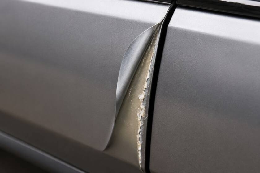 Ram — vinyl peeling back at a panel edge showing film thickness (SFG Wraps).